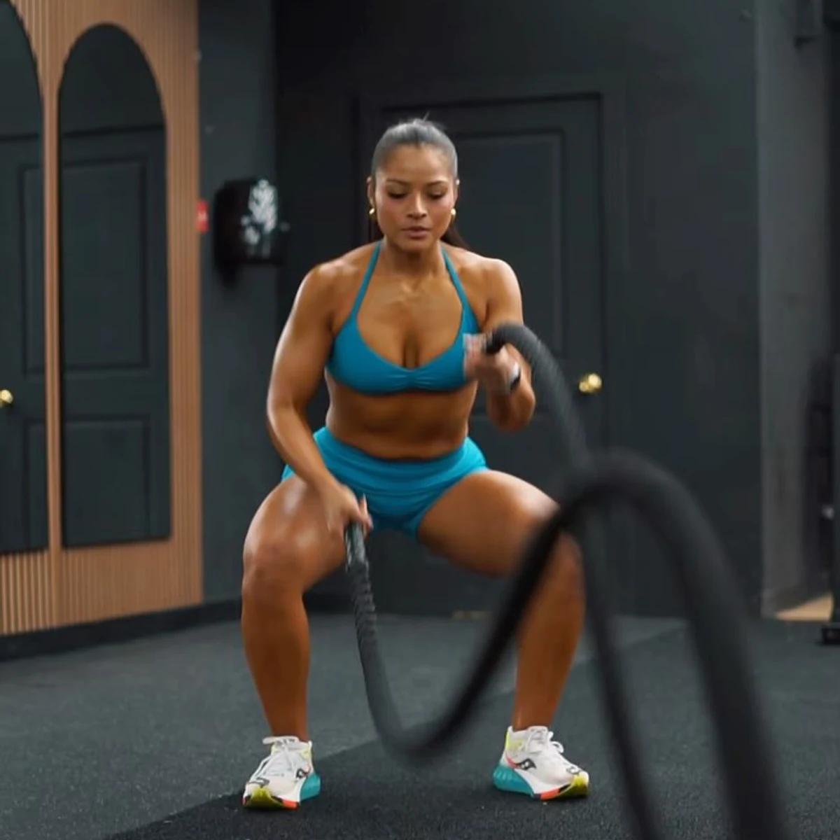 Woman working battle ropes inside the Grind to Glow studio
