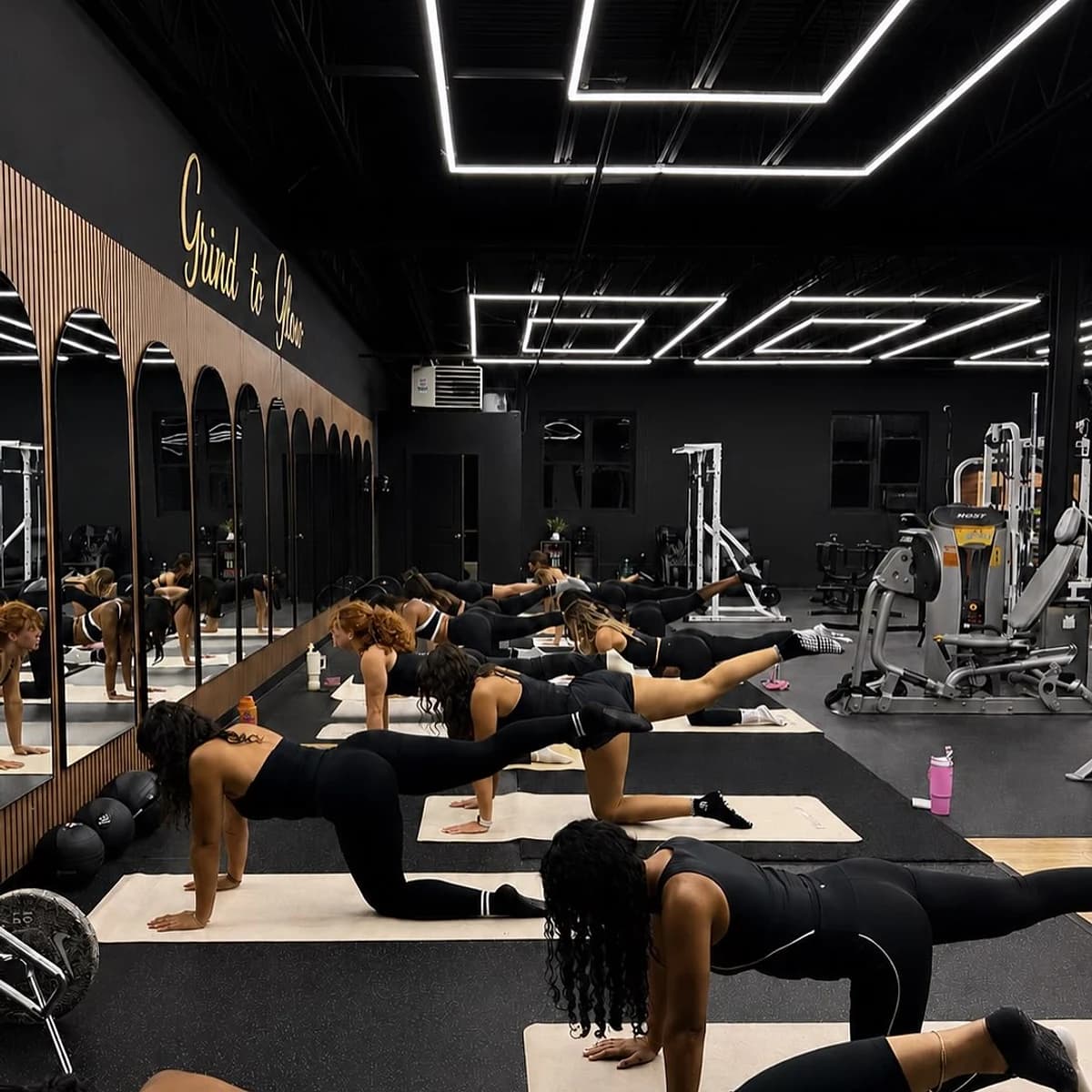 Women moving through a Mat Pilates class at Grind to Glow